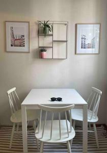 a white table with two chairs and a white table and two pictures at Central lux location, self check-in, ensuite with full kitchen in Helsinki