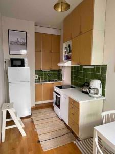 a kitchen with a white refrigerator and a stove at Central lux location, self check-in, ensuite with full kitchen in Helsinki
