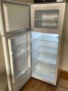 an empty refrigerator with its door open in a kitchen at Central lux location, self check-in, ensuite with full kitchen in Helsinki