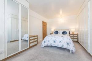 a bedroom with a bed and a large mirror at Rose Garden House in Luton