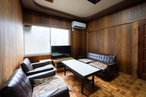Setouchi base - Vacation STAY 47136v في Mitoyo: غرفة معيشة بأثاث جلدي وطاولة