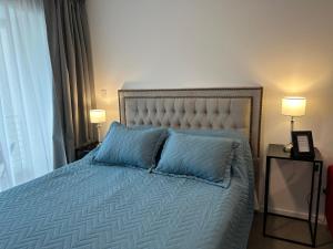 a bedroom with a bed with two blue pillows at Exclusivo Monoambiente zona Plaza Paso By Lofter in La Plata