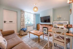 uma sala de estar com um sofá e uma mesa em No. 10, The Cottage em Framlingham