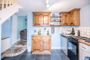 uma cozinha com armários de madeira e um fogão em No. 10, The Cottage em Framlingham