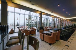 um restaurante com cadeiras, mesas e janelas em Hotel Blackfoot em Calgary