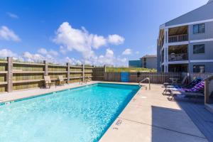 a swimming pool with patio furniture and a house at 5732 - Beach Music in Nags Head