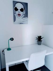 a white desk with a picture of a woman with sunglasses at Convenient Studio Apt Near Airport, Beaches & Food in Cupecoy
