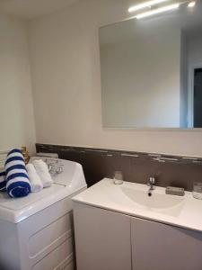 Baño blanco con lavabo y espejo en Convenient Studio Apt Near Airport, Beaches & Food en Cupecoy