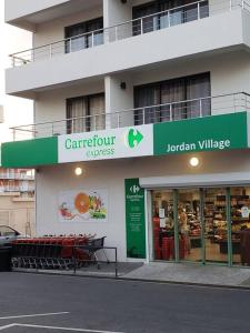 a store with a green sign on the side of a building at Convenient Studio Apt Near Airport, Beaches & Food in Cupecoy