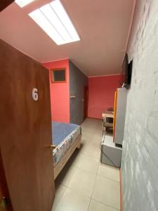 ein Schlafzimmer mit einem Bett in einem Zimmer mit roten Wänden in der Unterkunft Hostal Boutique F in El Quisco