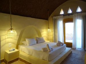1 dormitorio con 1 cama con 2 toallas en Ayujidda Nubian House en Asuán