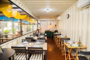 una fila de mesas y sillas en un restaurante en Shelter Hostel e Pousada en Ponta Porã