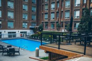 a swimming pool with a table and chairs and a building at Hotel Blackfoot in Calgary