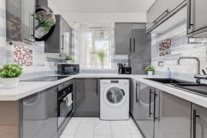 a kitchen with a washer and dryer in it at Deluxe 1 Bed Apartment - Battersea, Nine Elms & Vauxhall in London