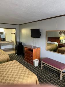 ein Hotelzimmer mit 2 Betten und einem Flachbild-TV in der Unterkunft Bedford Inn in Elk City