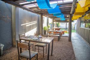 a patio with tables and chairs and blue lights at Shelter Hostel e Pousada in Ponta Porã