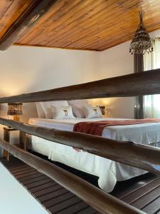 ein großes Bett in einem Schlafzimmer mit Holzdecke in der Unterkunft Lobo Guará Hospedagem Loft in Alto Paraíso de Goiás