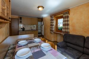 een woonkamer met een tafel en een bank bij Bait Di Farina - Trepalle in Livigno