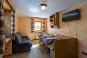 una piccola cucina con tavolo e televisore in una stanza di Bait Di Farina - Trepalle a Livigno