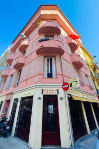 a pink building with a red door on a street at CHEZ TAMARA in Nice +6 photos