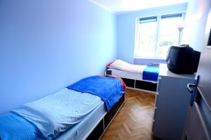 een kamer met 2 bedden en een bureau met een televisie bij Victus Apartamenty, Apartament Jantar in Sopot