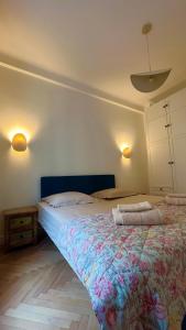 ein Schlafzimmer mit einem großen Bett und einer geblümten Decke in der Unterkunft CHEZ TAMARA in Nizza