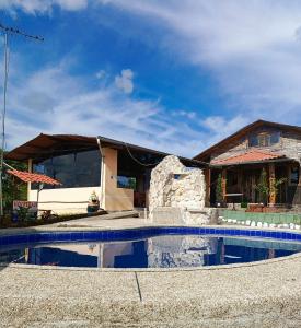 una casa con piscina frente a una casa en Hostería Cacique Wasi en Puyo