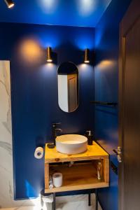 a blue bathroom with a sink and a mirror at Campolongo Tiny Chalet in Câmpulung +54 photos