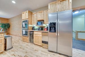 una cocina con nevera de acero inoxidable y armarios de madera en Bellaire Cabin at Shanty Creek Near Schuss Mtn! en Bellaire
