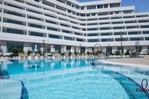 a large swimming pool in front of a large building at דירת סטודיו מעוצבת 50 מטר מהים - By Edomlux in Eilat