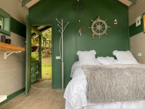 Habitación verde con cama con almohadas blancas en Rancheria Loft Chalet, lago privado, en Rionegro