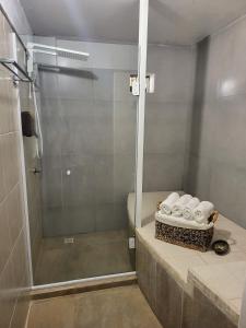 a bathroom with a shower and a toilet and towels at La Roca Studio 7 in Praia do Rosa