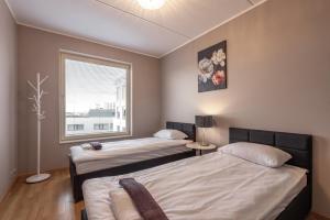dwa łóżka w pokoju z oknem w obiekcie AirHome - Heart of City Center w Tallinnie