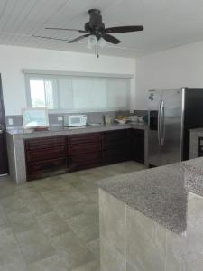 a kitchen with a refrigerator and a ceiling fan at Beautiful oceanfront townhouse LA Barqueta Nice Las Olas resort in Guarumal