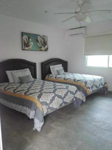 a bedroom with two beds and a ceiling fan at Beautiful oceanfront townhouse LA Barqueta Nice Las Olas resort in Guarumal