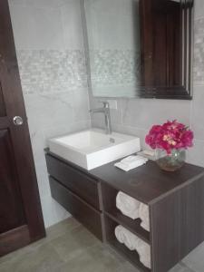 a bathroom with a sink and a vase of flowers at Beautiful oceanfront townhouse LA Barqueta Nice Las Olas resort in Guarumal