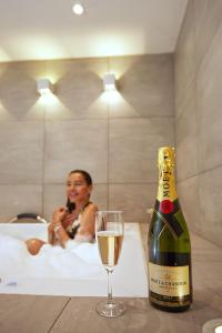 a bottle of champagne and a wine glass in a bath tub at DUO BOUTIQUE HOTEL in Medellín