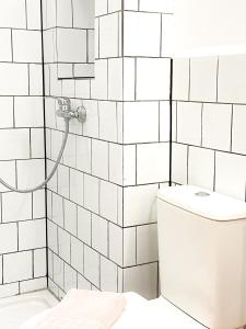 y baño de azulejos blancos con aseo y ducha. en Casa Veronica 3 , 1 dormitorio, en Las Galletas