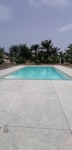 a large blue swimming pool with trees in the background at Villa Blue in Boukot Ouolof