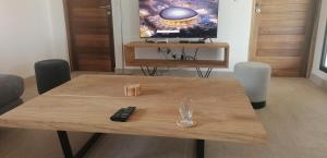a wooden table with a remote control on top of it at Villa Blue in Boukot Ouolof