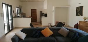 ein Wohnzimmer mit einem Sofa mit Kissen darauf in der Unterkunft Villa Blue in Boukot Ouolof