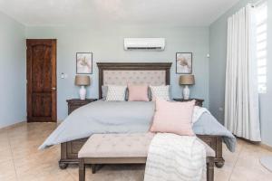 a bedroom with a large bed with pink pillows at Casa Cielo in Rincon