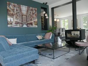 a living room with a blue couch and a tv at Villa piscine city center / 15 min Chps Elysées in Nanterre