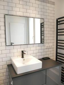 a white bathroom with a sink and a mirror at Villa piscine city center / 15 min Chps Elysées in Nanterre