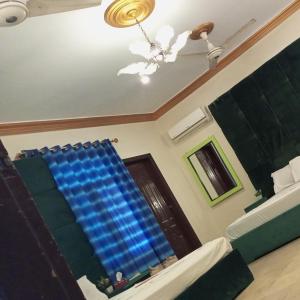 um quarto com uma ventoinha de tecto e uma janela azul em Johar Hill view Guest House em Carachi