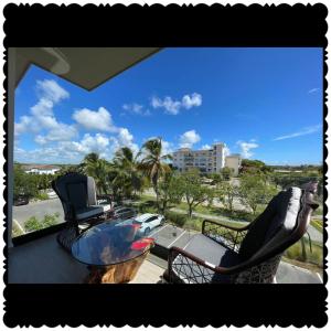 balcón con sillas, mesa y vistas al océano en Apartament with private beach in CAP CANA punta cana, en Punta Cana