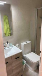 ein Badezimmer mit einem WC, einem Waschbecken und einem Spiegel in der Unterkunft Apartamento recién reformado en Barajas Pueblo in Madrid