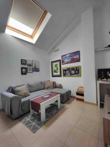 ein Wohnzimmer mit einem Sofa und einem Tisch in der Unterkunft Apartamento recién reformado en Barajas Pueblo in Madrid