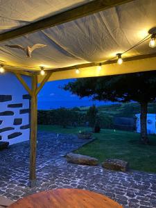 a pergola with lights and a stone patio at Home Near the Clouds - Refúgio in Nordeste