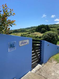 a blue gate with a sign that reads al appetizer at Home Near the Clouds - Refúgio in Nordeste